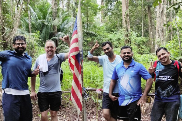 Gruppenbild mit Landesflagge vor Regenwald mit Sam, Marco, Venu, Kannan und Danajaya von Smith & Nephew 